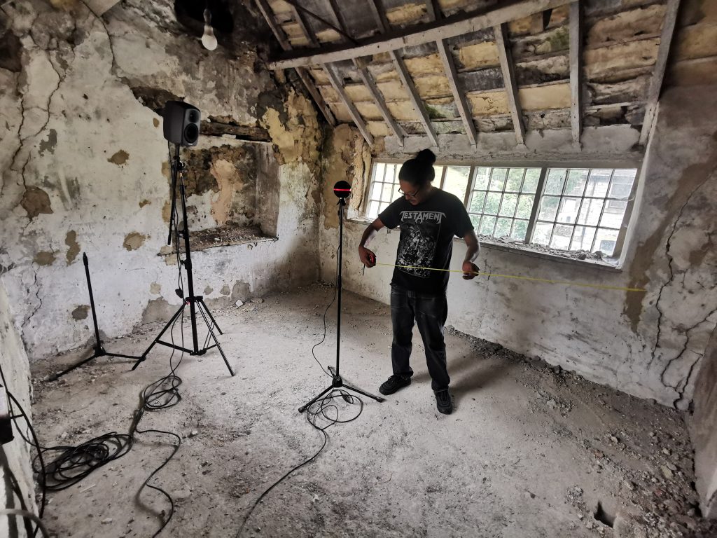 University of Derby student taking 3D audio measurements in the Bonsall Framework Knitting Workshop, pre-restoration.