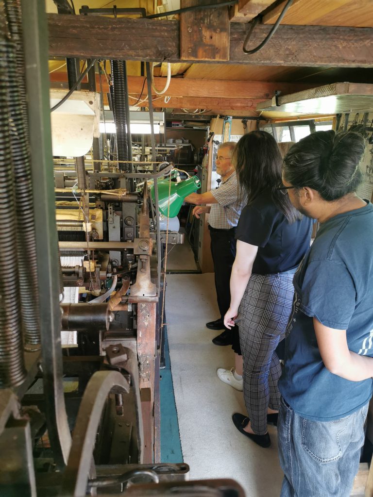 University of Derby staff and students listening to Martin Green explaining the history of his workshop.